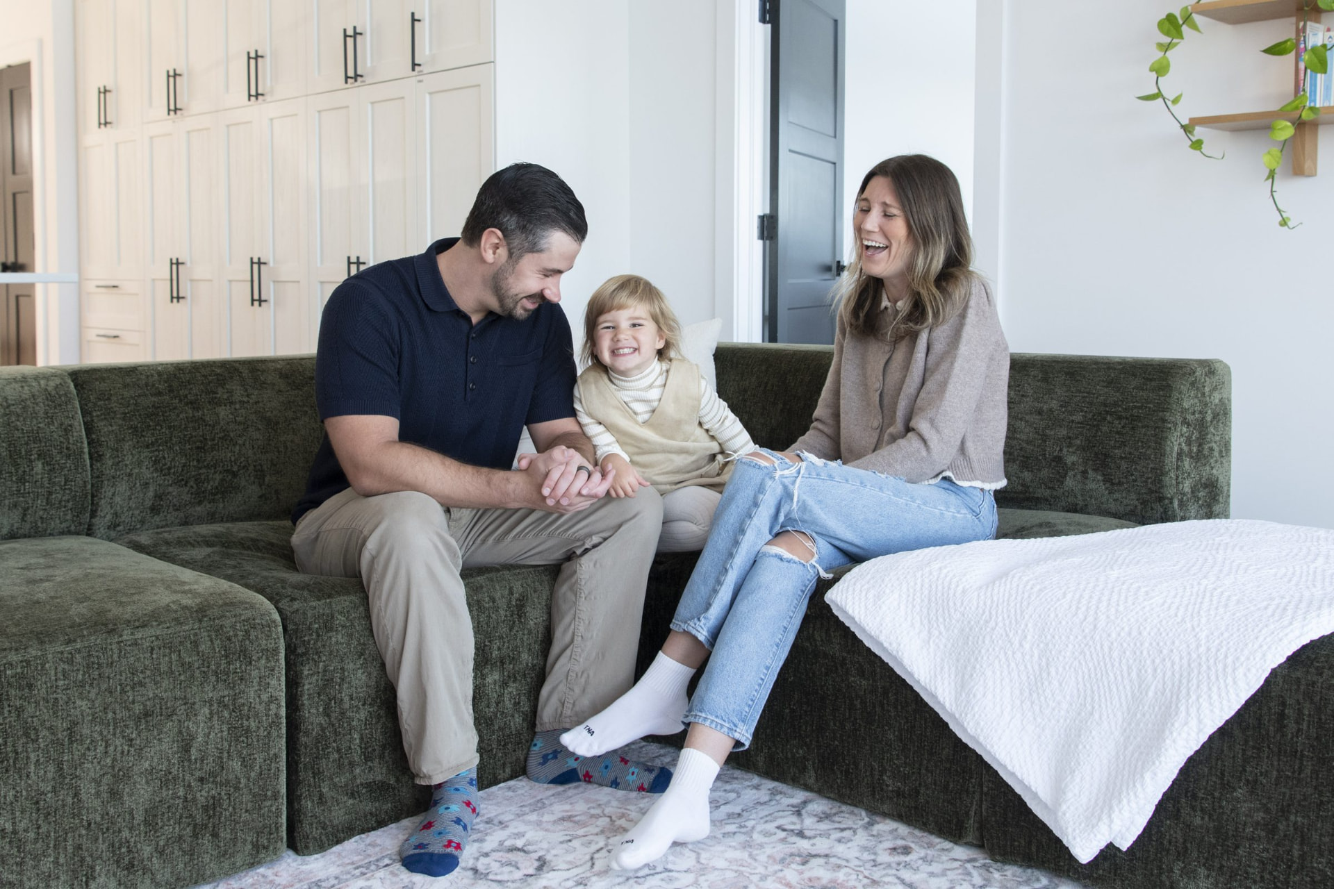 Geoff, Veronika and their daughter relaxing on the sofa at Bayswater Beach Retreat