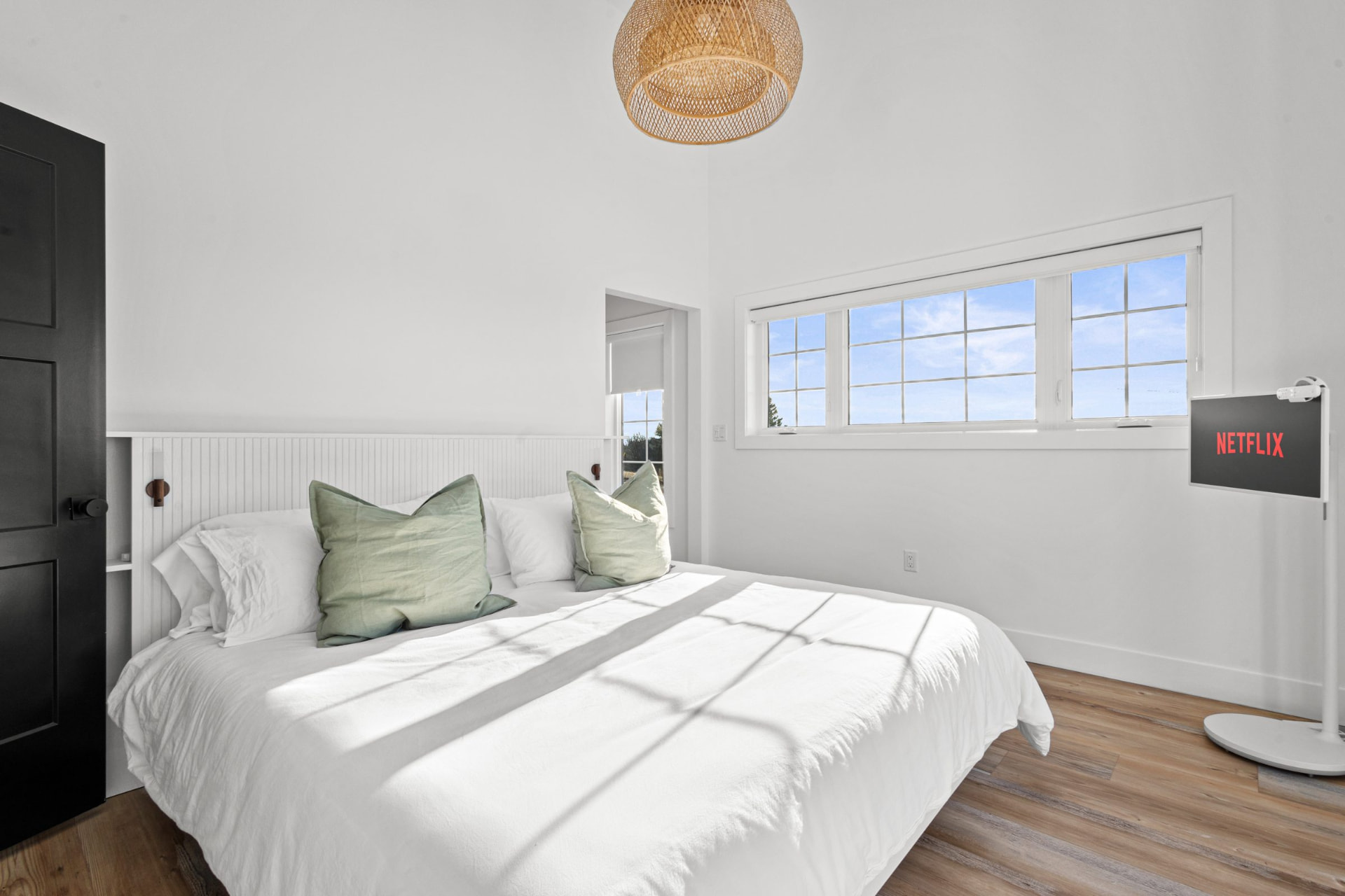 Second primary suite with a king bed, warm wood and soft natural light