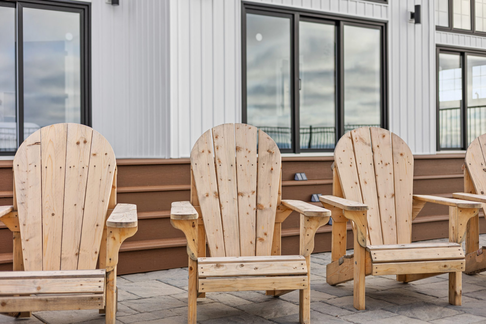 Adirondack chairs on the lawn facing the sunset over the water