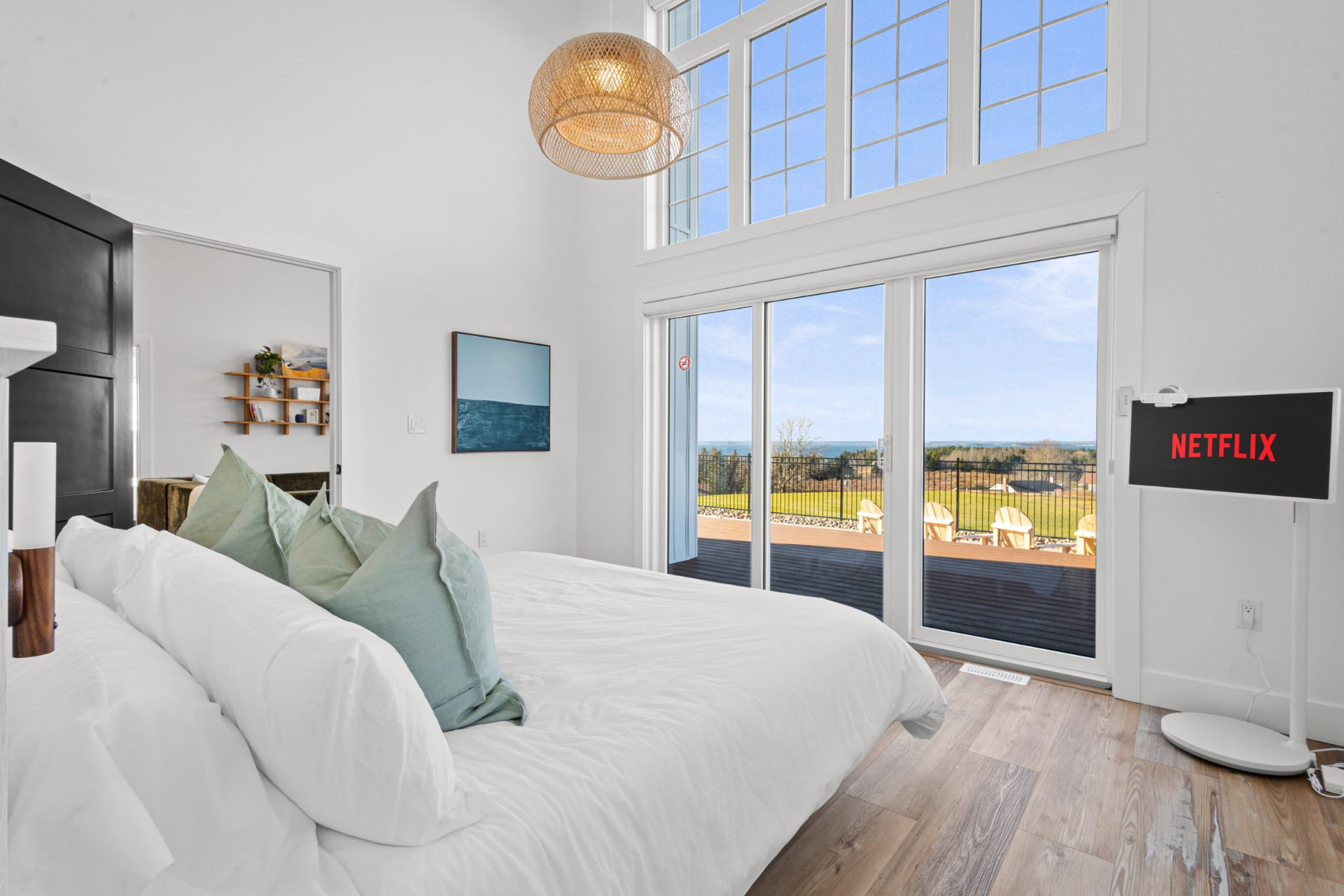 Primary suite with a king bed facing a window with an ocean view